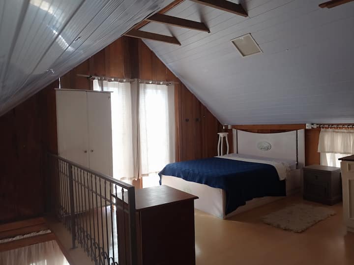 ห้องนอนเตียงใหญ่ที่มีพื้นที่โล่งและมีตู้เสื้อผ้าสำหรับผ้านวม