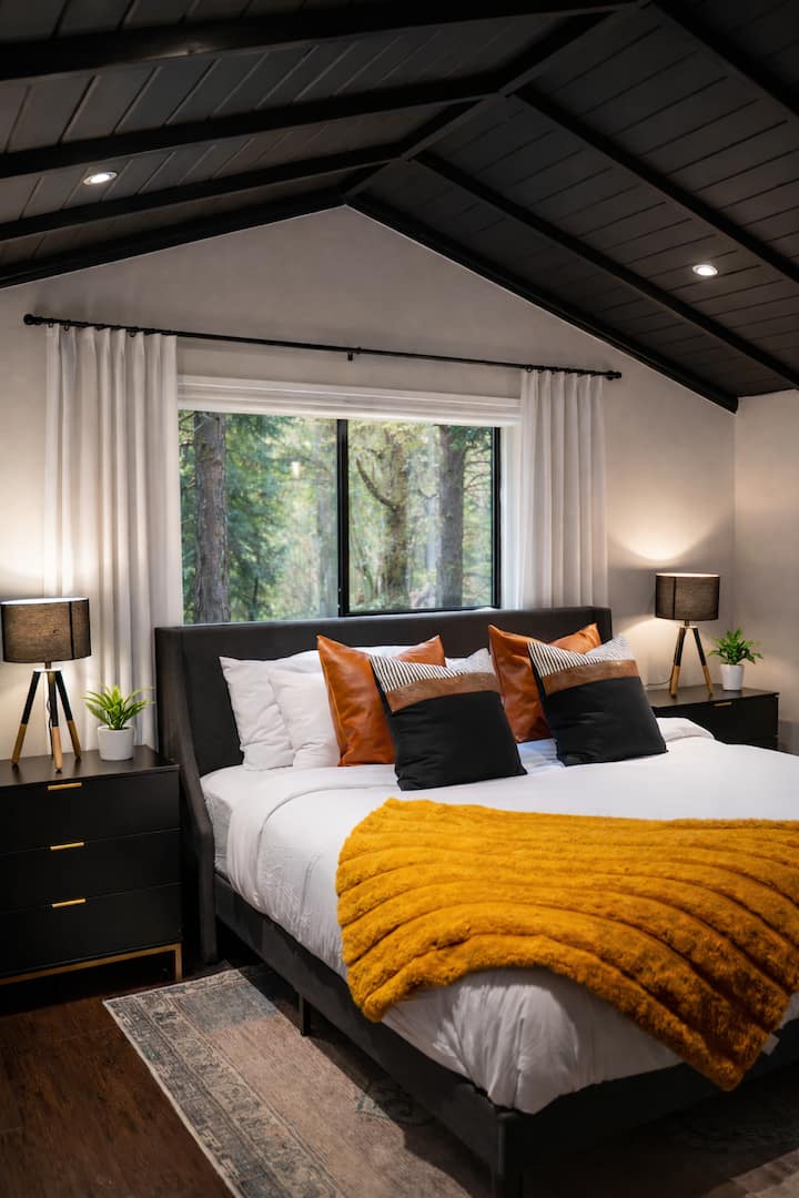 להיסחף בנוחות  - חדר השינה הראשי המזמין מתגאה בנגיעות מודרניות, מבטאים חמים ונוף יער שליו לחופשה האולטימטיבית בבקתה.