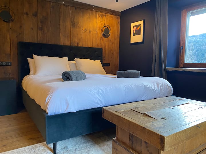 Manželská posteľ veľkosti Super King, vlastná kúpeľňa. Zásuvky a priestor na zavesenie. Dvere vedúce do prednej záhrady