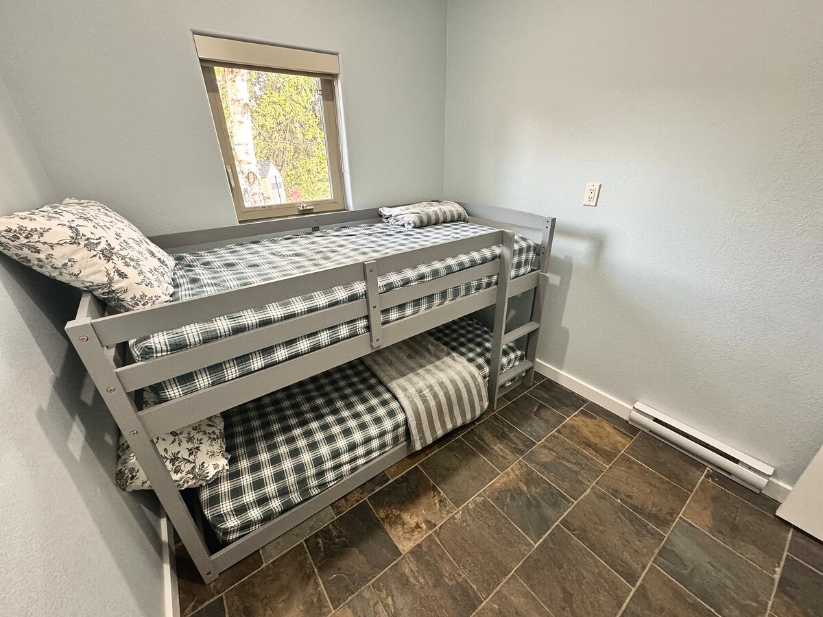 Cozy bunk room with twin beds and soft linens—perfect for kids, friends, or extra guests to unwind after a day by the lake.