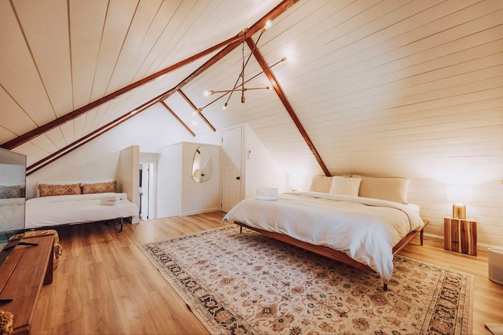 Specious attic bedroom with a king and full bed, TV, closet, and dresser. Comes with an air purifier for extra comfort. King bed has a Casper mattress, and the full has an IKEA mattress, both comfy for a good night’s sleep.
