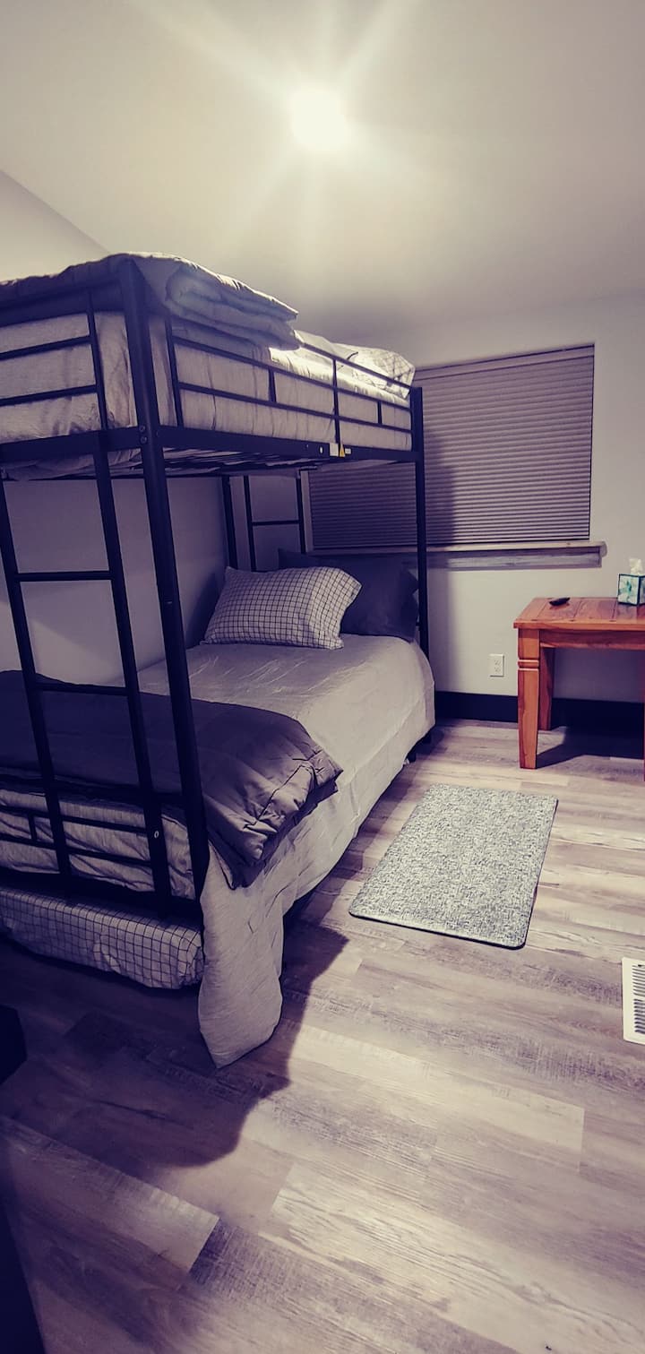 Dormitorio 2 con literas individuales y una cama nido doble, armario y televisión.