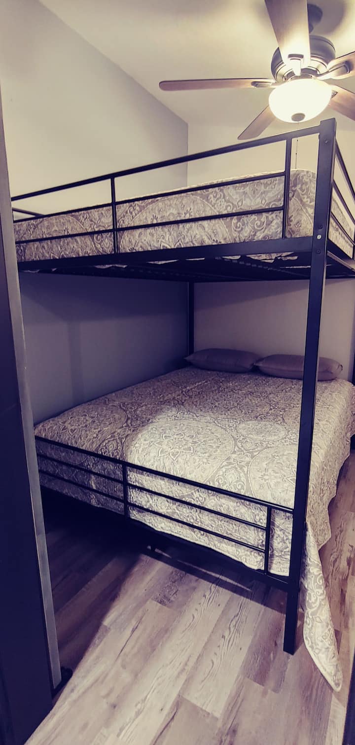 Dormitorio  4 con literas tamaño queen, televisor de pantalla grande, armario, cama doble y un baño privado de tamaño completo con amplia ducha a ras de suelo.