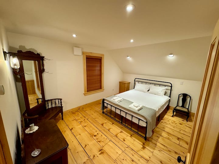 חדר שינה בקומה השנייה — חדר הסנוניות של האסם. כולל שידת אגוזים עתיקה ועץ מסדרון עתיק עם מראה.