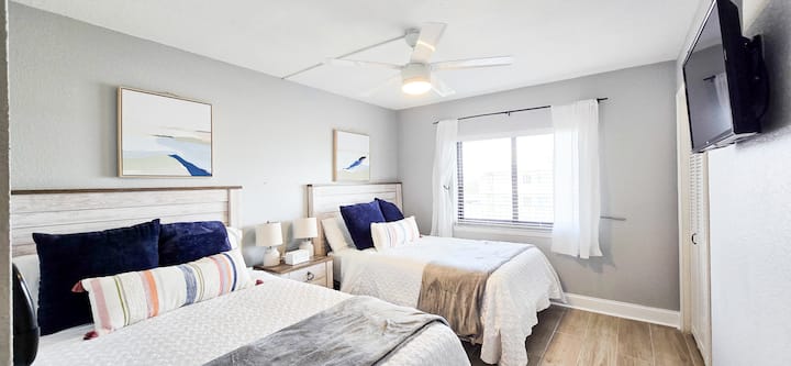 Rymligt gästrum med (1) dubbelsäng och (1) full säng och en smart-tv