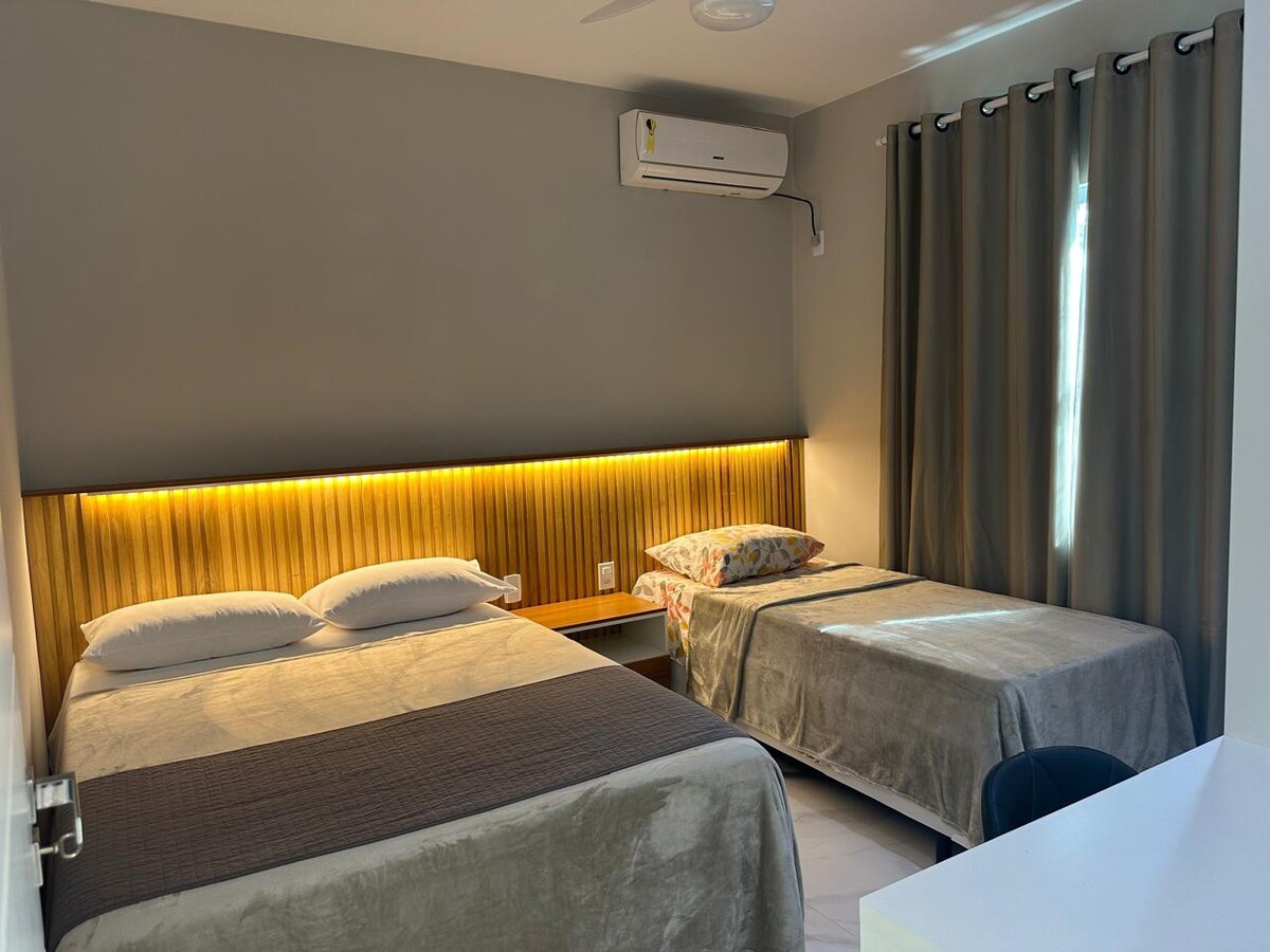 卧室配有双人床和单人床、空调和遮光帘。