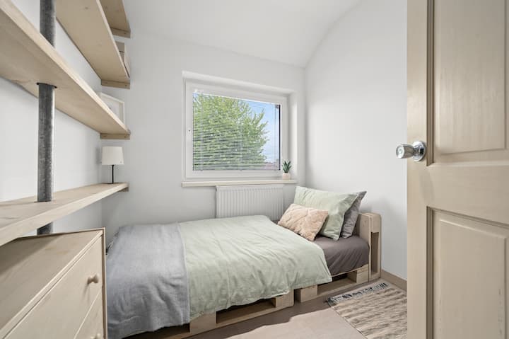 舒适的卧室，配有舒适的床、柔软的床上用品和令人放松的柔和色调。 大窗户让充足的日光照射进来，而遮光百叶窗则确保您能安然入睡。 精心设计的置物架和紧凑的储物空间使空间实用而温馨。