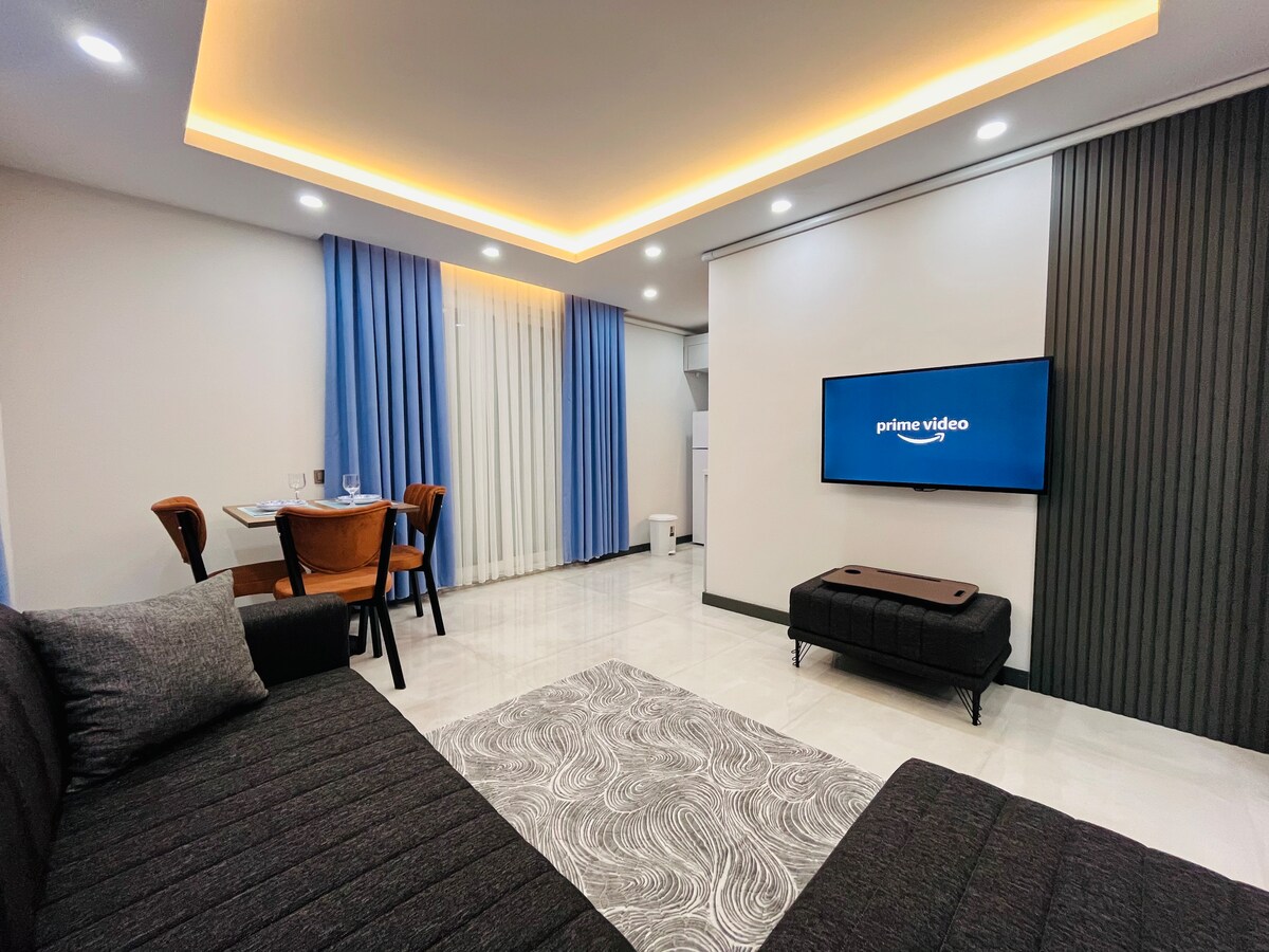 This spacious living room, equipped with comfortable seats, is ideal for relaxing and having a pleasant time.