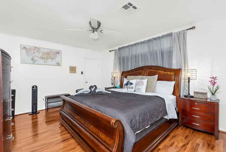 غرفة نوم فسيحة بسرير كينج ومساحة أرضية مفتوحة، توفر مساحة كبيرة للتنقل والاسترخاء بشكل مريح.