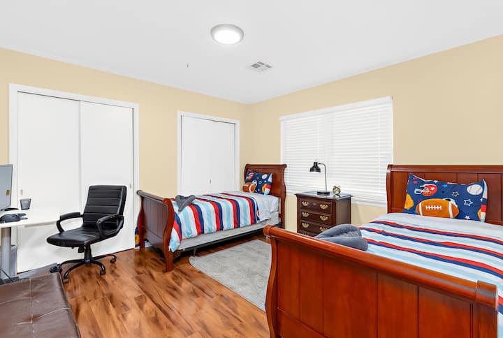 غرفة نوم بها سريران منفصلان، مما يجعلها خيارًا عمليًا للأطفال أو الأصدقاء أو الضيوف الذين يفضلون الحصول على مساحة نوم خاصة بهم.