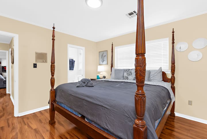 يشكّل السرير الكلاسيكي ذو الأربعة أعمدة محور الغرفة، مما يضفي لمسة تقليدية مع الاستمرار في توفير مكان مريح وواسع للراحة.