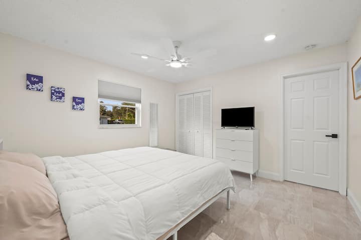Guest room with private 1/2 bathroom, king size bed, and television.
