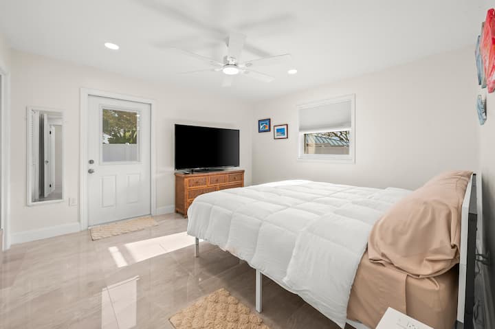 This room has a work space with desk, large TV,  large hanging closet, and access through the door to the hot tub and pool area.