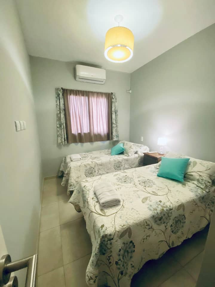 غرفة نوم ثانية بسريرين مزدوجين بالحجم الكامل يمكن تحويلهما إلى سرير بحجم كوين لزوجين.  تحتوي الغرفة على مكيف هواء بارد وساخن