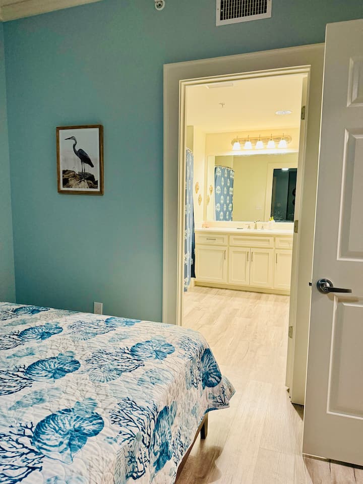 ห้องพักพร้อมเตียงคู่ 2 เตียงที่มองเห็นห้องน้ำขนาดใหญ่สำหรับผู้เข้าพัก สามารถเข้าถึงห้องน้ำได้จากห้องนอน 