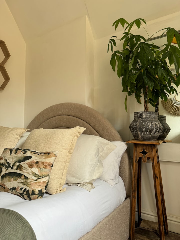 Krevat dopio "king-size" me hapësirë të varur dhe një tavolinë pune me pamje nga oborri i pasmë.