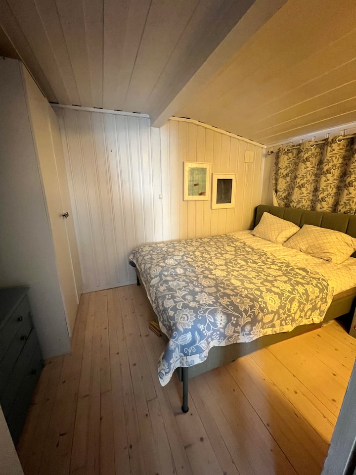 غرفة نوم مريحة مع سرير مزدوج وخزانة ومغسلة.