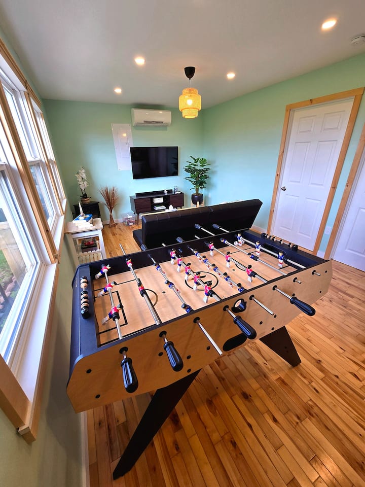 غرفة معيشة مريحة مع مكيف هواء وتدفئة وطاولة كرة قدم للمرح دون توقف!