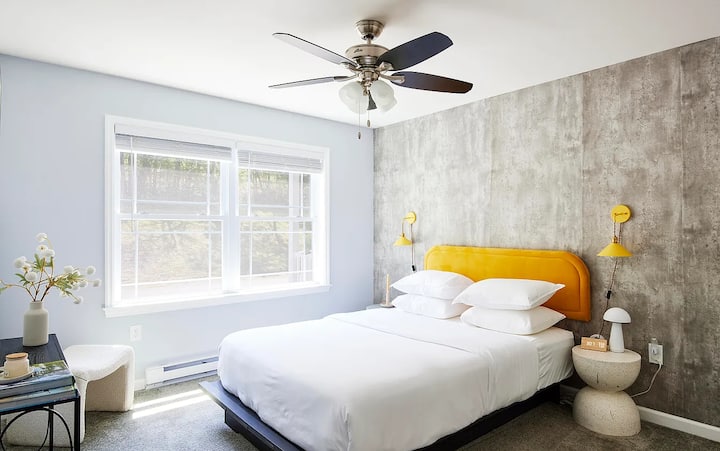 You'll love waking up in Bedroom 2's queen bed — the bold mustard headboard and modern decor make this room a real showstopper.