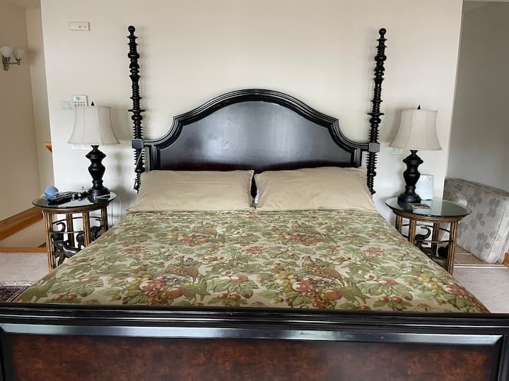 Veliki bračni krevet s kaminom u sobi i balkonom iznad jezera.  Priključena kupaonica s jacuzzi kadom. 