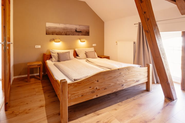 El segundo dormitorio tiene un diseño particularmente acogedor. Las vigas de madera originales del antiguo desván le dan al espacio un ambiente rústico y cálido.
