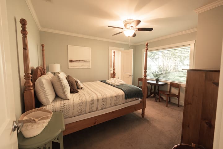 Otro dormitorio de invitados bellamente amueblado con una cama tamaño queen y un diseño cómodo.