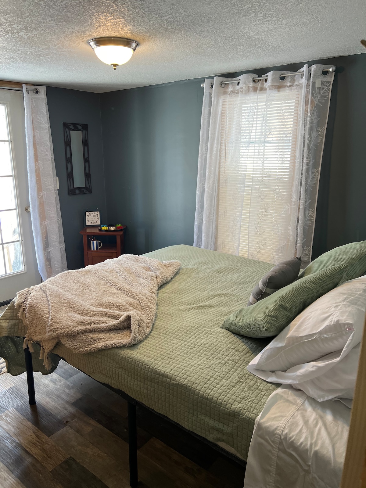 De enige slaapkamer met zijn nieuwe queensize bed. Grote kast heeft planken voor het ophangen van kleding. Kast is perfect voor  het opbergen van tassen. 
Slaapkamer heeft een deur die naar de achtertuin leidt. 
Je vindt ook de spellen op de bijzettafel! 