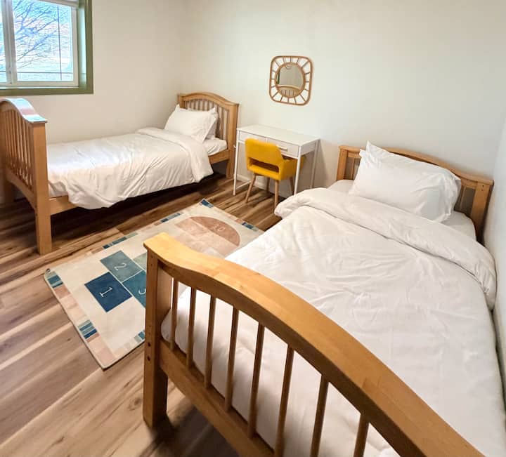 Un dormitorio cómodo con un escritorio para actividades, mantas adicionales y una pequeña selección de juguetes para niños, ideal para familias que viajan con niños.
