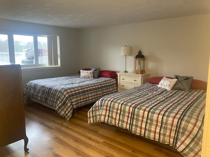 Priestranná izba s 2 manželskými posteľami veľkosti Queen. Priľahlá kúpeľňa. Veľké okno s výhľadom na vodu  