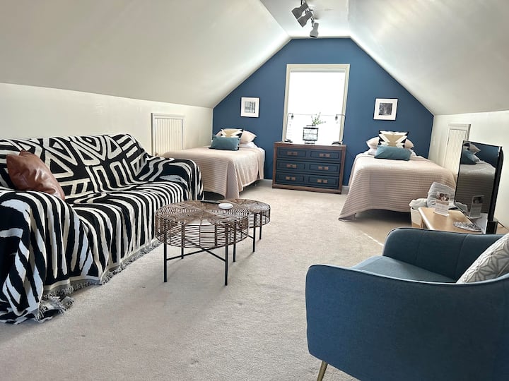 مساحة علوية كبيرة يمكن أن تتسع لـ 4 أشخاص (سرير كوين + سريرين فرديين) مع مساحة غرفة معيشة صغيرة خاصة بها وتلفزيون وثلاجة صغيرة ومكتب