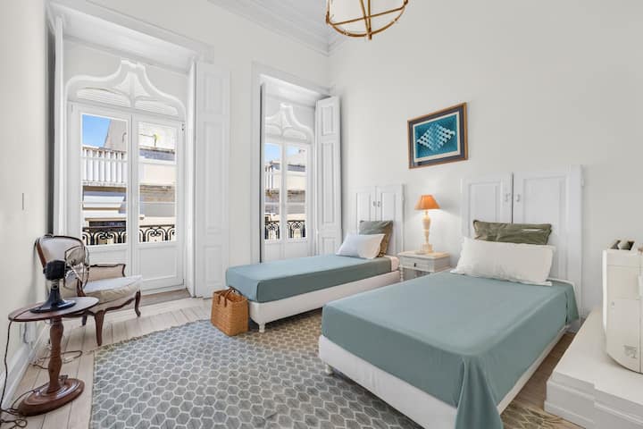 Bright twin bedroom with tall French doors and elegant historic charm
