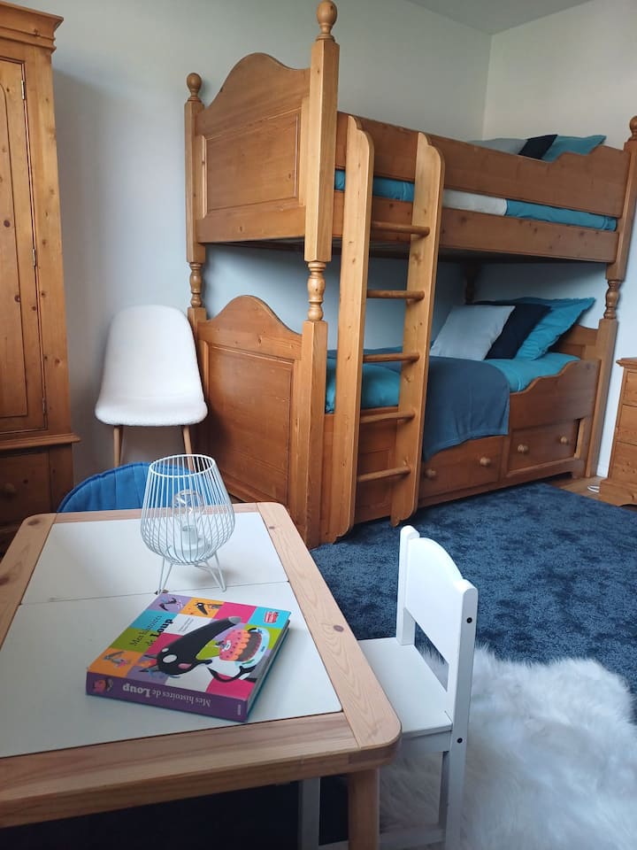 Arriba, disfrute de una habitación amplia y luminosa con una cama alta de dos camas de 90 , un gran armario y una cómoda de almacenamiento y aire acondicionado. Un espacio cómodo y creativo, ideal para relajarse y reponer energías.