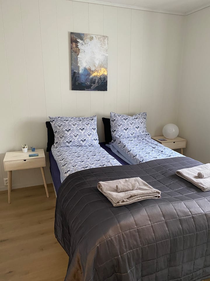 ห้องนอนใหญ่พร้อมโต๊ะข้างเตียงและตู้เสื้อผ้าขนาดใหญ่