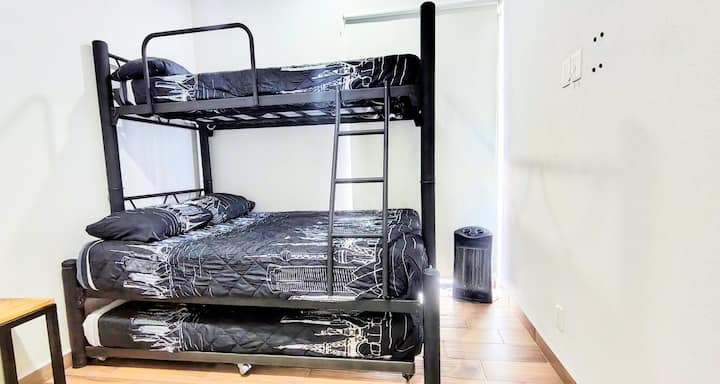 Recámara ideal para varios huéspedes, equipada con litera y cama adicional, perfecta para familias o amigos.