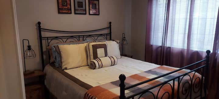 تحتوي الطاولات الطرفية على محطة شحن، وتحتوي الغرفة على مروحة سقف.