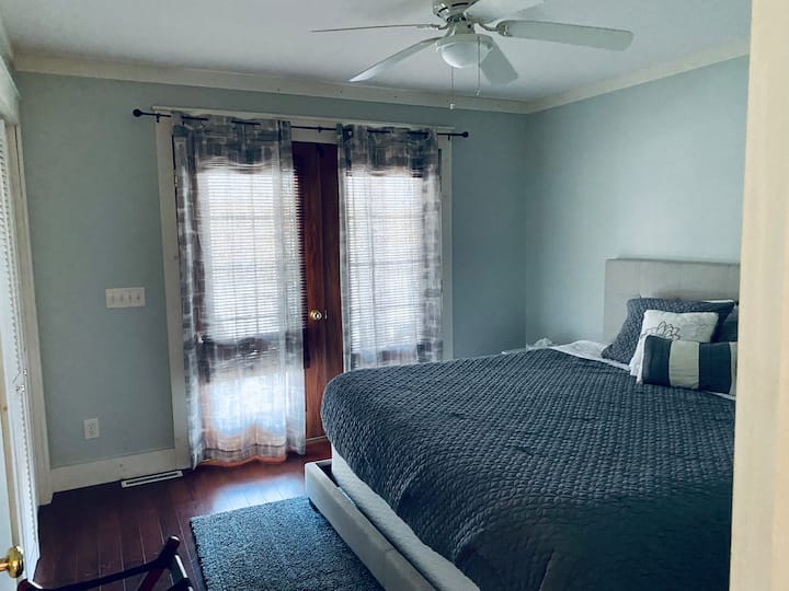 Cama tamaño king. Las puertas francesas conducen al balcón cubierto. Ventilador de techo, armario, vestidor, portaequipajes, estaciones de carga de la mesita de noche. 