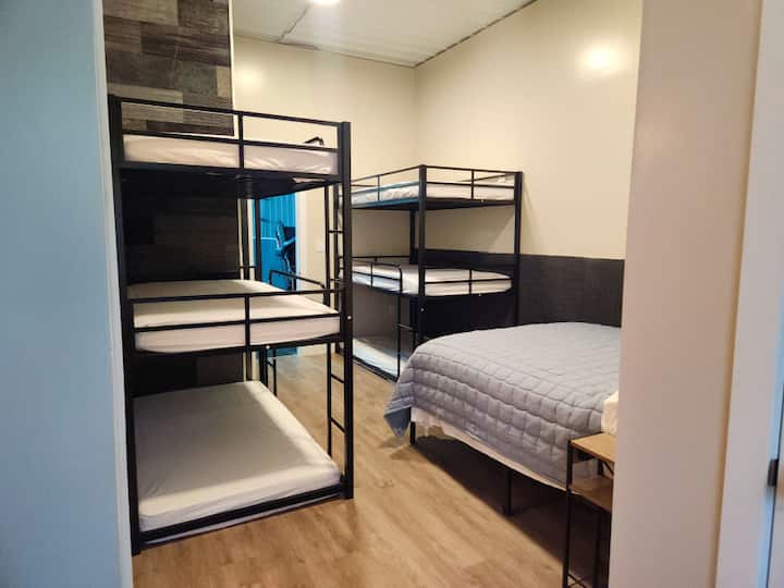 The bunk room sleeps 10. There are 2 sets of triple bunks, a queen size bed and a queen size pull out couch.  You must bring your own bedding for the bunks. There is an attached bathroom for this room.  This bedroom door has an electronic lock. 