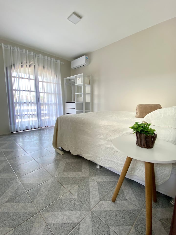 Chambre avec lit Queen Size, penderie et climatiseurs. Accès au balcon avant (avec crochets à hamac).