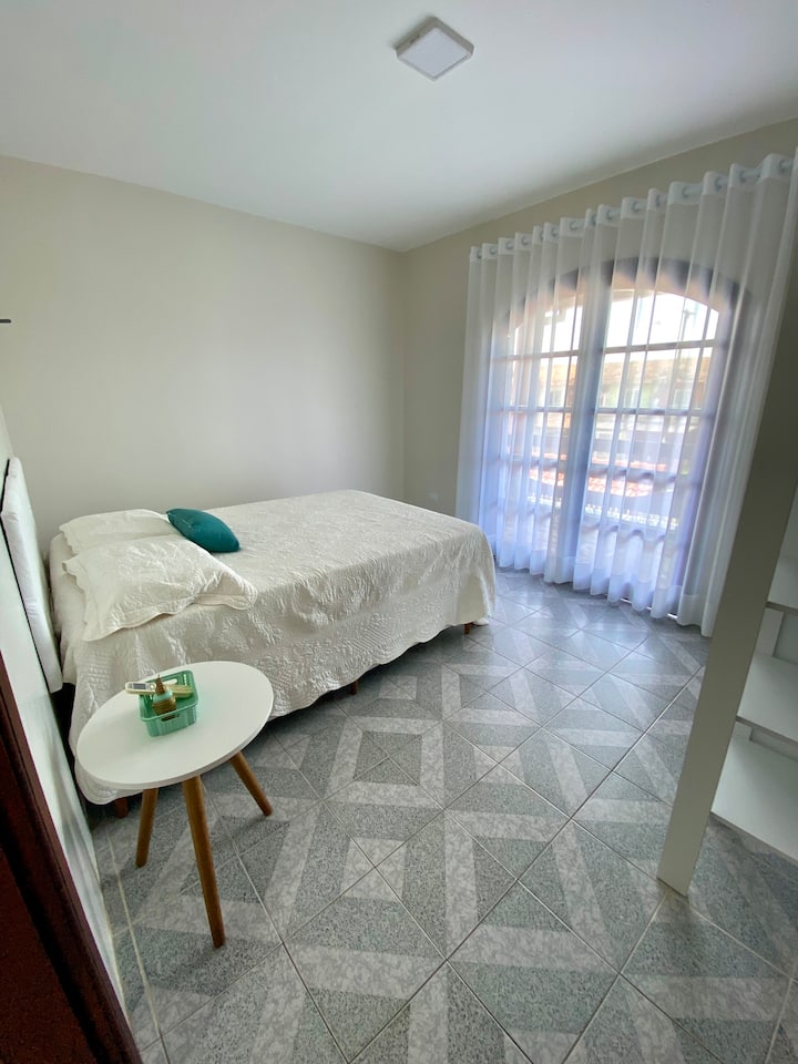 Chambre avec climatisation, lit double et armoire. Balcon avec des crochets de hamac.