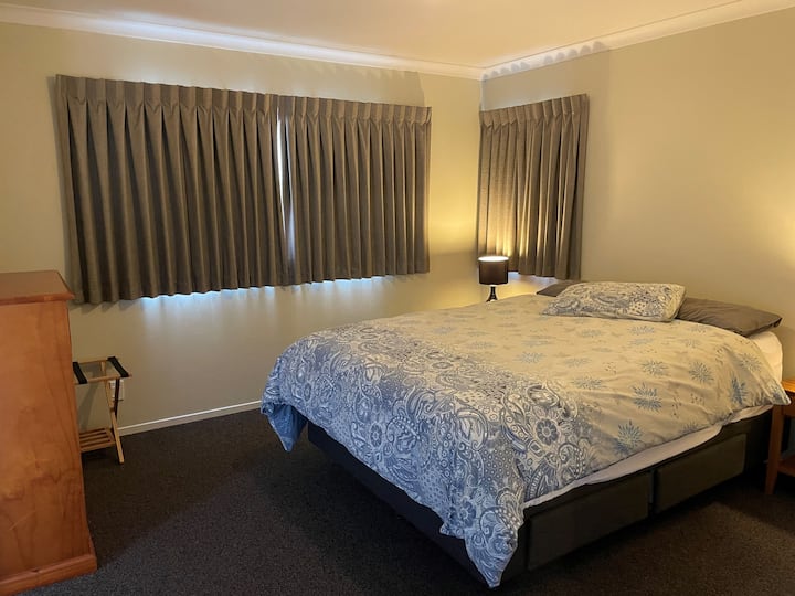 Cama queen en un amplio dormitorio separado