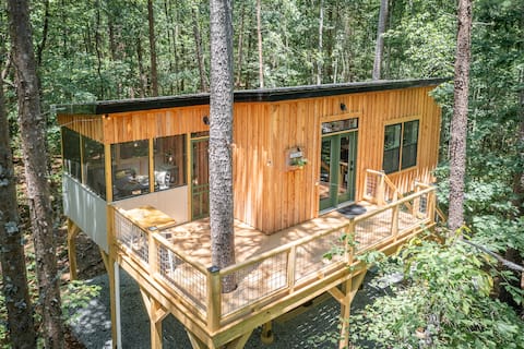 Modern storybook treehouse with hot tub