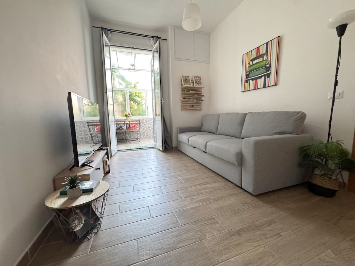 غرفة معيشة بسرير أريكة مريح (أريكة بمقعد ثلاثة مقاعد، والتي تصبح سريرًا فرنسيًا). الدخول إلى الشرفة والحديقة.