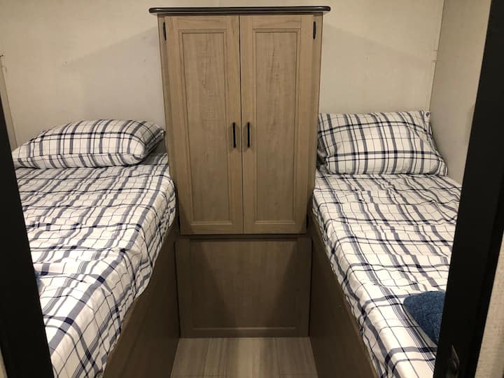 Se retiraron las literas superiores para que las camas más bajas fueran más fáciles de usar para los adultos.  Una cama es de tamaño doble y la otra es de una litera más estrecha. Se proporciona un taburete, pero no se muestra aquí. 