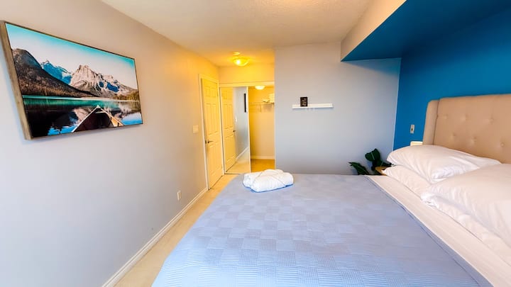 Vestidor en el dormitorio principal con un espejo de piso a techo y una cama euro top-firm de Property Brothers de HGTV, Scott Living. 