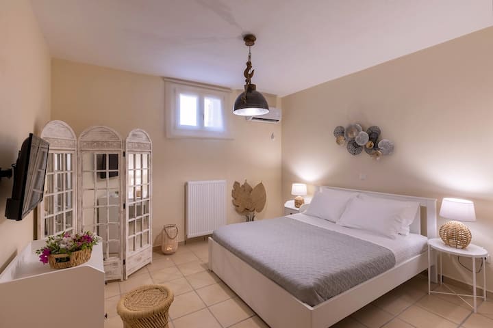 A cozy and stylish bedroom on the lower level, with soft lighting, warm beige tones, and elegant décor. The comfortable double bed, modern amenities, and charming details create a relaxing retreat. Perfect for a peaceful stay.