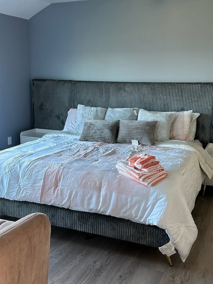 Un espacio de estudio aislado dentro de la casa, con una cama tamaño king, un sofá compacto, TV y una zona de cocina equipada con microondas y nevera. El baño adjunto ofrece una vista fantástica y abundante luz solar.