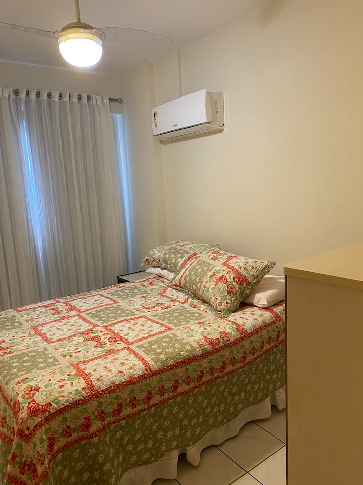 Manželská posteľ, stropný ventilátor a klimatizácia.