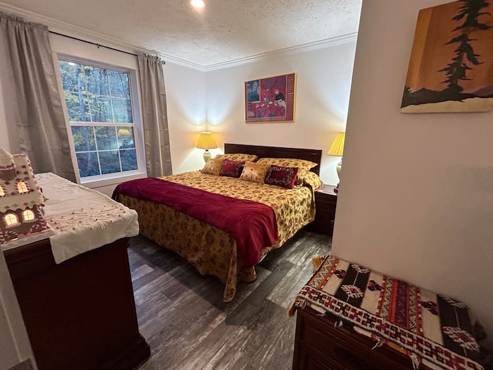 The comfortable king size bed in this bedroom overlooks the magical forest and Buckeye Creek in the backyard. 