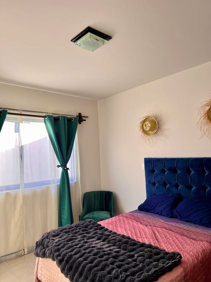 Habitación secundaria con cortinas dobles, lámpara de noche con luz cálida y fría