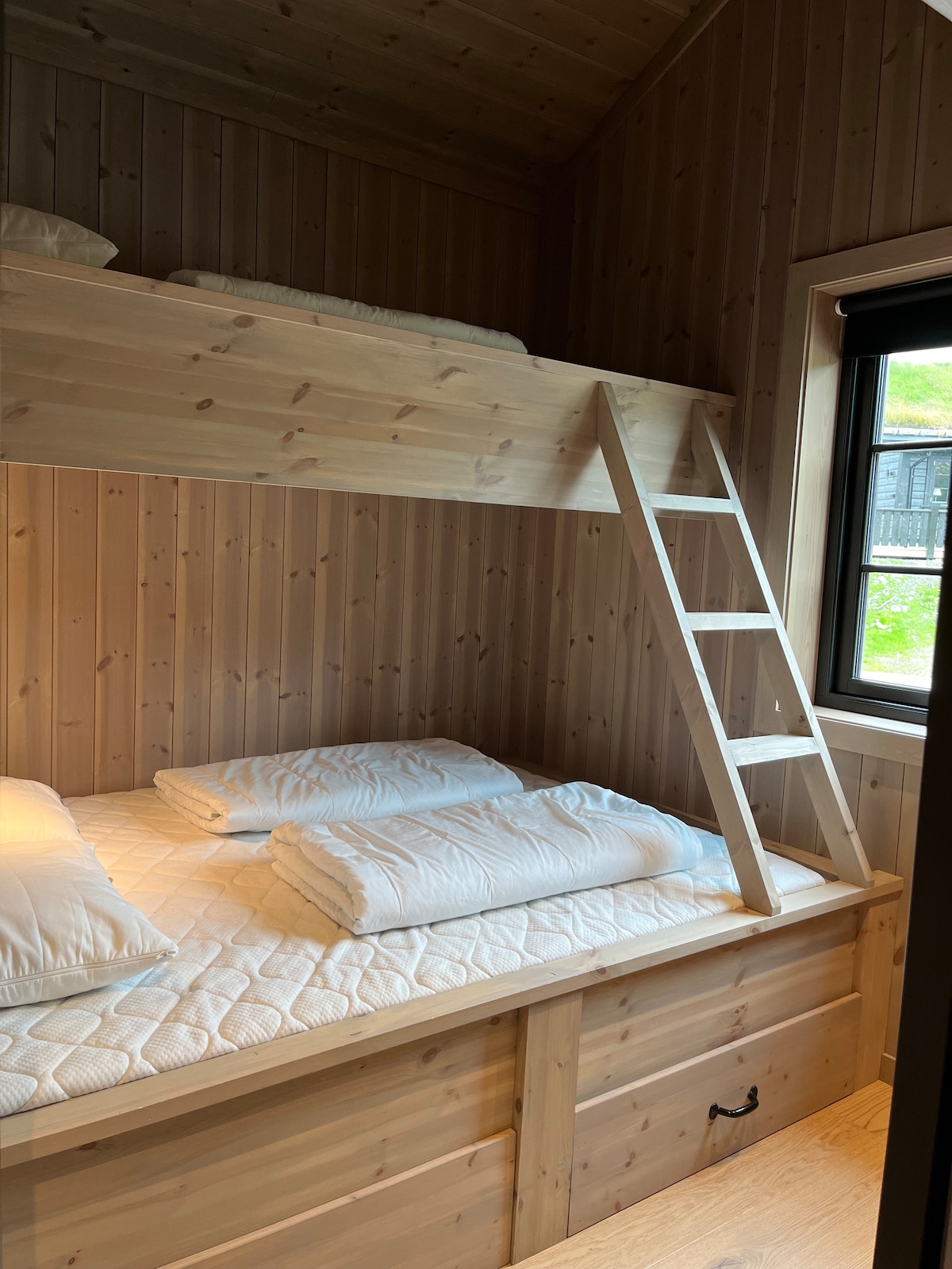 В спалня 1 има семейно двуетажно легло. Долната е 140x200 и лесно отнема 2 - ма души. Горната е 90x200. Практично място за съхранение под леглата. Не са осигурени спално бельо и кърпи, така че гостите трябва да ги донесат. Като алтернатива можете да наемете жилище.